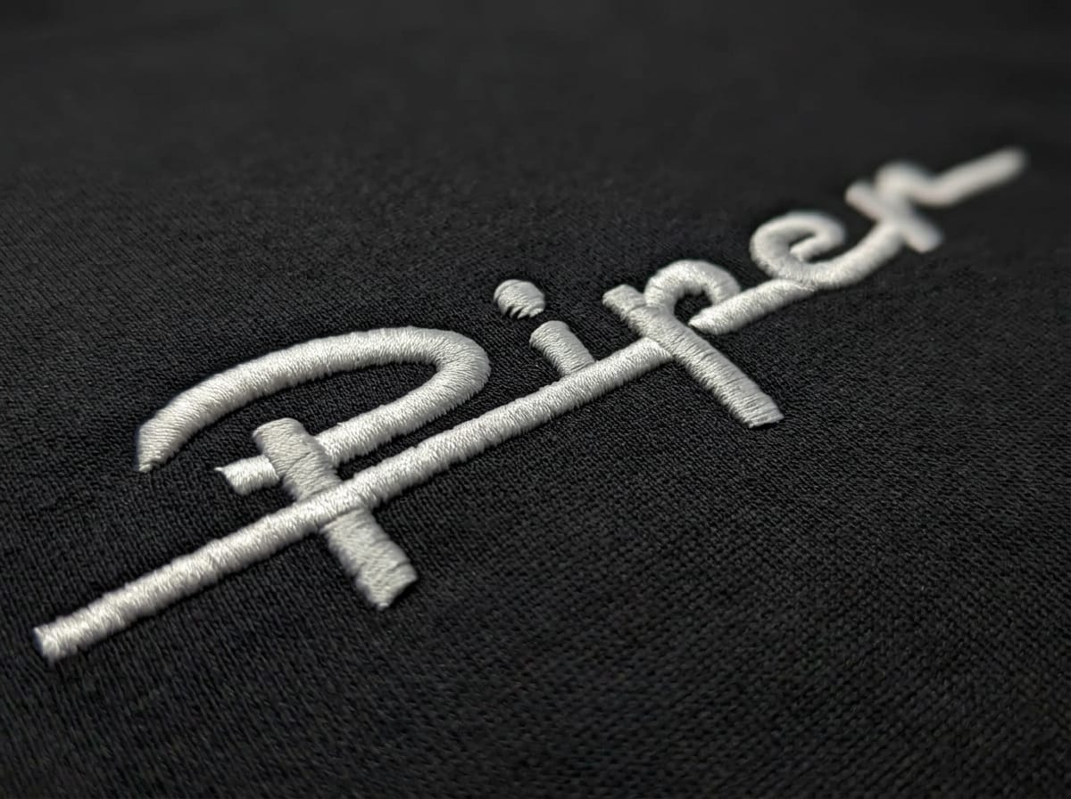 3D embroidery detail of the Piper logo in a close-up of the thread – produced on our Tajima TMEZ at Stoff³ Kassel